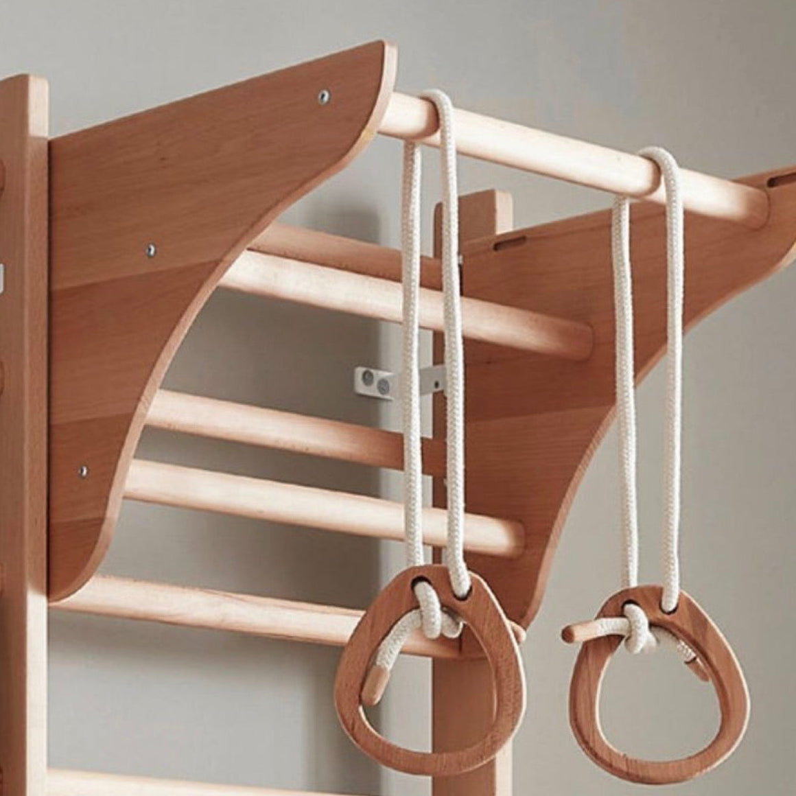 Wooden climbing ladder with rings on a plain wall