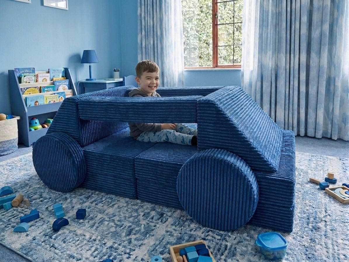 Child playing with a blue modular play couch in a room with blue walls and toys scattered on the floor.
