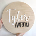 Round wooden sign with a custom name in acrylic on a wooden background
