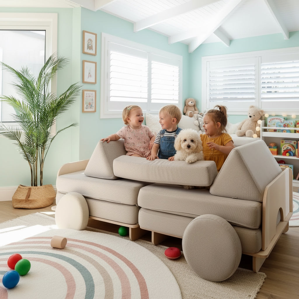 A beige modular sofa with a chunky wheel base and round caster wheels, shown in a bright, modern living room with three children and a small dog sitting on it.