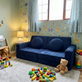 Children's playroom with blue play sofa, toys, and colourful decor.