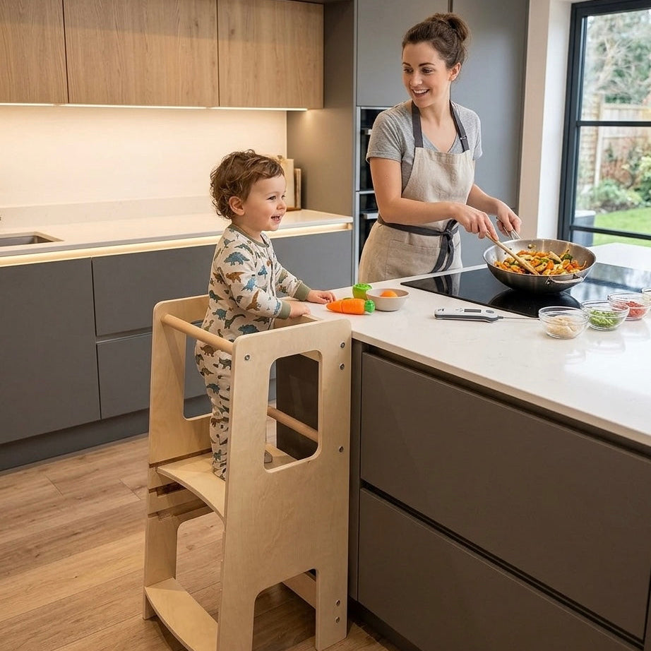 Woman cooking in a modern kitchen with a child on a wooden learning tower.