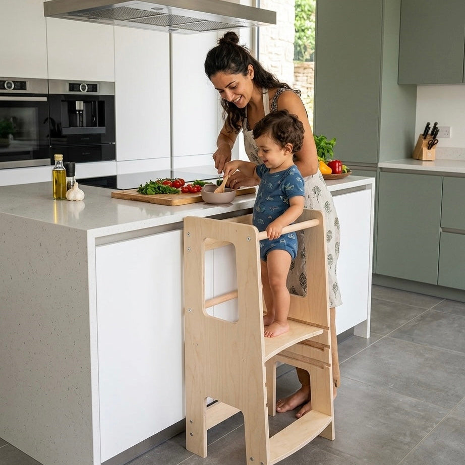 Woman and child in a kitchen with a wooden step stool learning tower.