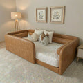 Brown leather toddler bed in a room with framed pictures on the wall.