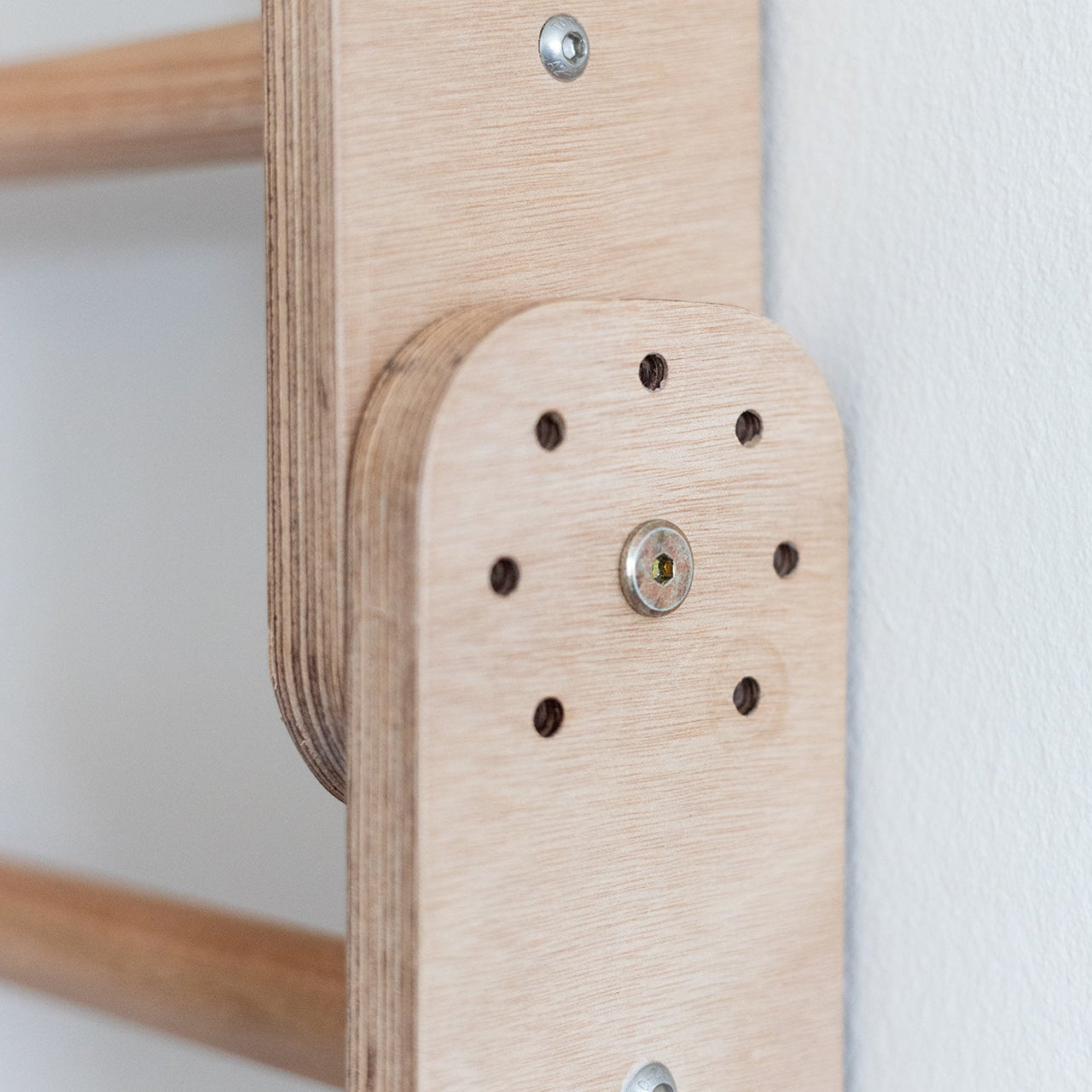 Close-up of a wooden shelf bracket with screws on a white background